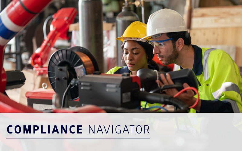 Two engineers in safety gear operate industrial machinery in a factory setting. Text overlay reads "COMPLIANCE NAVIGATOR.