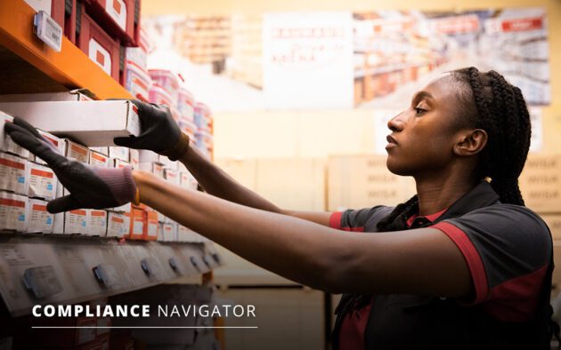 Person in a warehouse reading labels on boxes