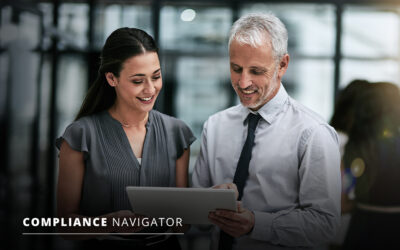 Two colleagues discussing content on a tablet in a modern office setting. A woman is holding the tablet while a man points at the screen. Text reads "Compliance Navigator" in the corner.