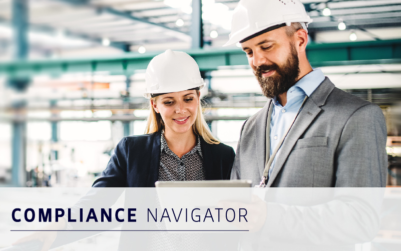 Two professionals wearing hard hats review a tablet in an industrial setting, supported by workforce management solutions. The text "Compliance Navigator" appears over the image.
