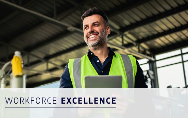 Smiling man in a high-visibility vest holds a tablet inside an industrial building; text reads "Workforce Excellence.