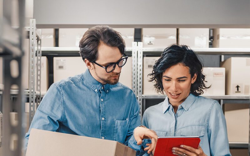 A man and woman looking at a tablet.